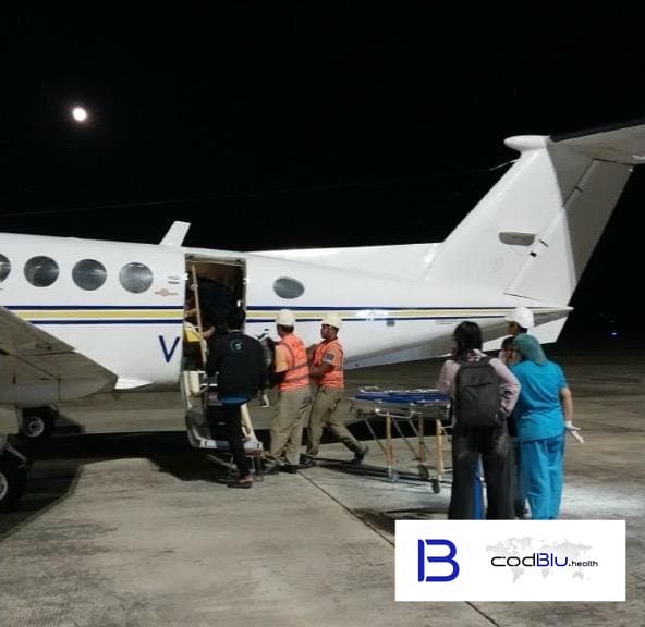 Patient boarding a charter air ambulance at night with the ground and medical crew